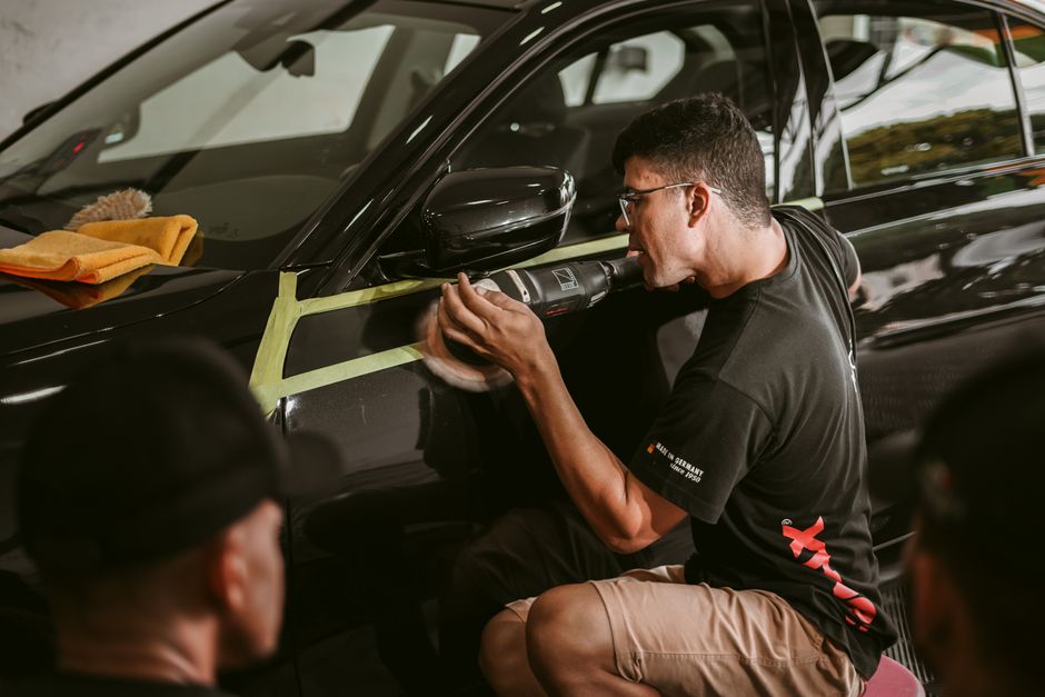 Professional car detailer inspecting paint finish
